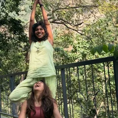 Playful partner yoga in the sun. These interactions help build trust, communication, and a lighthearted sense of connection within the group.