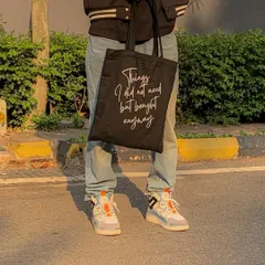 A closer look at our black quote tote, perfect for adding a touch of personality to your outfit. The 27-inch handles make it comfortable to carry on your shoulder, even when it's full.