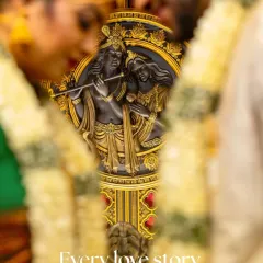 This is a detail shot focusing on a beautiful Radha Krishna idol, with the couple blurred in the foreground. It’s a creative way to symbolize the couple's union while honoring the cultural elements of the ceremony.