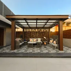 A closer look at a custom pergola with intricate, laser-cut wooden screens that provide privacy and a beautiful play of light and shadow. The structure is perfect for an intimate seating arrangement.