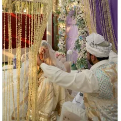 A candid moment from a Nikah ceremony, viewed through a screen of flowers. We focus on creating decor that not only looks beautiful but also allows for intimate, picture-perfect moments.