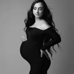 A stunning solo portrait in a classic black gown. The soft light and gentle breeze in her hair add a touch of movement and grace to this dramatic monochrome shot.
