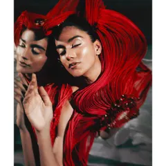 An artistic interpretation using mirrors for the Vaishali S. campaign. The reflection creates a dual perspective on the fluid, ribbon-like texture of the red garment, adding depth and a surreal quality to the fashion portrait.