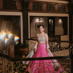 A full-length shot showing the bride's complete Sangeet look. The natural makeup allows her vibrant pink Seema Gujral lehenga to truly pop, creating a perfect balance.