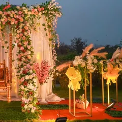A closer look at the details of the floral arch and swing. You can see the rich mix of pink, white, and red flowers, with fairy lights woven in for a sparkling effect as evening approaches.