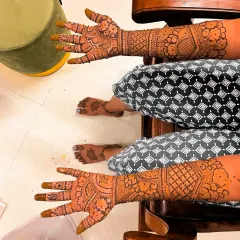 A complete bridal mehndi package includes detailed work on both hands and feet, as shown on this happy bride relaxing after her session.