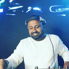A smiling shot from behind the decks. I truly love what I do, and my passion for music and creating a great party atmosphere shines through in every performance.