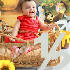 A big, happy laugh from the half-birthday girl. Her bright red dress and the cheerful cartoon backdrop make this a wonderfully vibrant and happy portrait.