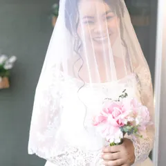 A joyful moment captured through the veil. The bride's happy smile shines through, and her soft, radiant makeup enhances her natural beauty without being overpowering.