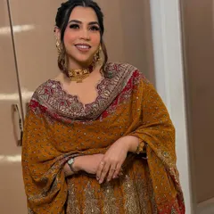 A stunner in a beautiful mustard and red outfit. The makeup is warm and glowing, with a defined eye that complements her traditional attire perfectly.