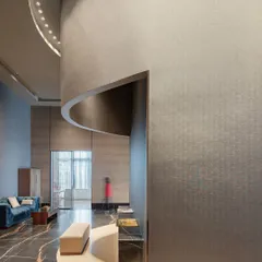 Curving walls and carefully planned circulation paths guide visitors through the Godrej South Estate Experience Centre. This image shows how the architecture itself directs the journey, creating a sense of discovery as one moves from one zone to the next. The play of light and shadow on the textured walls adds depth and intrigue.