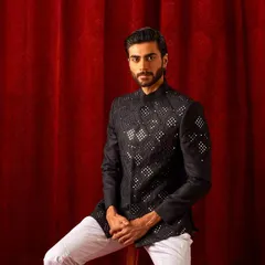 This black bandi jacket with geometric mirror work is a modern classic. It's a versatile piece that can be worn over a kurta for a festive look or even with a shirt for a fusion style.