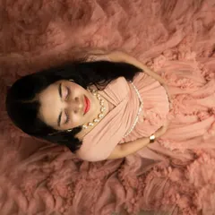 A serene top-down portrait in a delicate peach gown. This artistic angle focuses on your peaceful expression and the beautiful texture of the dress.