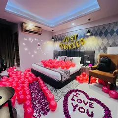 For a truly special "Just Married" or first-night surprise, I transform a hotel room into a romantic haven. This decoration features hundreds of balloons, a custom rose petal message on the floor, and elegant lighting.