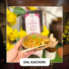 A guest holding a serving of Dal Kachori in a traditional leaf bowl. This classic snack is a perfect addition to a festive menu, like this one for a Ganesh Chaturthi celebration.