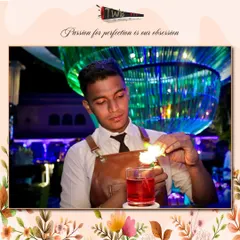 A bartender carefully flames an orange peel over a Negroni. This classic technique releases citrus oils that add a bright, aromatic complexity to the cocktail.
