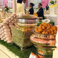 A closer look at our chaat counter setup. The combination of rustic grass, traditional copper and brass vessels, and neatly stacked bowls creates an authentic and inviting atmosphere.
