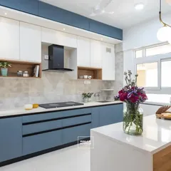 This modern modular kitchen features a striking dual-tone design with serene blue base cabinets and crisp white overhead storage. The quartz countertop island provides extra workspace and a casual dining spot, perfect for a busy family home.