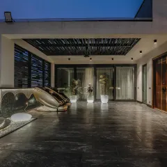 Another zone of the Vikaspuri terrace, this one featuring a slatted pergola roof and seamless access to the interior spaces.