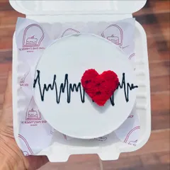 This bento cake features a heartbeat line with a textured red velvet heart. It's a popular choice for anniversaries and Valentine's Day.