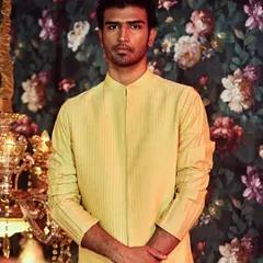 For a more subtle look, this pintucked bandhgala jacket in a vibrant yellow offers texture and sophistication.