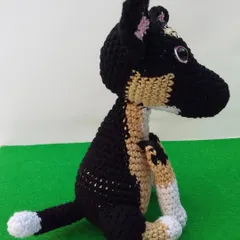 A side view of the custom dog amigurumi, showing the placement of the colors on its back and tail. Getting these details right is so important for a pet replica.