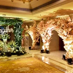 I create enchanting entrances that transport guests the moment they arrive. This beautiful walkway features arches of delicate pink cherry blossoms and a custom neon sign, setting a romantic and magical tone for an engagement or reception.