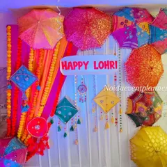 A colorful backdrop for a Lohri celebration, featuring vibrant Rajasthani umbrellas, kites, and marigold garlands to create a joyful and festive photo corner.