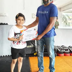 We celebrate every achievement, big or small. Here, one of our proud young members receives her certificate for successfully completing our MMA summer camp, a testament to her hard work and dedication.