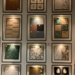 This wall of framed tiles acts as a design library. It showcases a variety of styles you can mix and match, from floral and geometric patterns to textured and multi-toned tiles, helping you find the perfect combination.