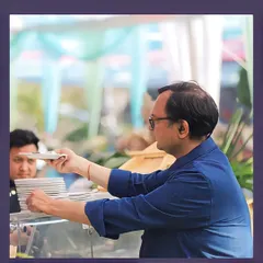 A member of our team carefully arranging plates at the buffet, demonstrating our focus on maintaining a perfect presentation throughout the event.