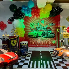 For the little car enthusiast, I designed this complete race car themed party. The setup includes a custom printed backdrop, themed plinths, car cutouts, and even a floor decal that looks like a road. It’s an immersive experience for a high-energy birthday.