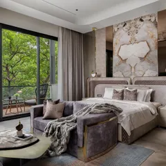 This master bedroom was designed as a quiet getaway within the home. We connected it to the outdoors with large sliding doors and used a palette of warm tones, soft textures, and a statement marble headboard to make the indoors feel calm and indulgent.