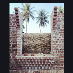 Construction in progress at the Samyak Yoga retreat. The air is filled with the earthy smell of lime mortar as the brick walls rise, framed against the coconut trees. This is what building with natural, traditional materials feels like.