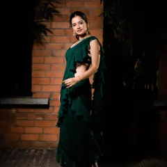 This full-length shot shows the beautiful flow of the emerald green ruffled saree gown. The layers of ruffles add movement and a contemporary feel to the classic saree drape.