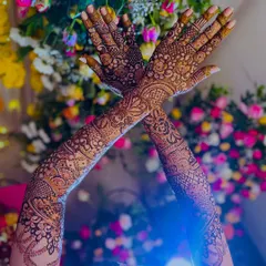 A dramatic shot of the bride's arms raised, showing the full extent of her beautiful bridal henna.