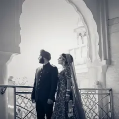 A timeless black and white portrait of a Sikh couple, framed by a beautiful archway, creating a classic and elegant composition.