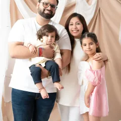 A classic studio portrait of a happy family of four. I focus on capturing genuine smiles and comfortable poses, creating a timeless image that reflects the warmth and connection of your family.