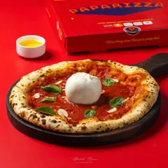 A Neapolitan-style Burrata pizza, photographed for Paparizza's online ordering platform. The lighting is designed to emphasize the fresh, creamy burrata and the perfectly baked crust, making it irresistible for delivery app users.
