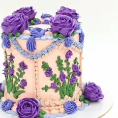 A close-up of the hand-piped purple buttercream roses and lavender sprigs.