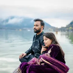 A serene and majestic shot of the couple on a Shikara boat in Dal Lake, Kashmir. The misty mountains in the background add a sense of peace and grandeur to this destination pre-wedding photo.