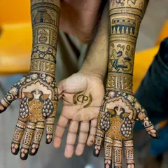 This unique engagement mehendi tells the couple's story, with illustrations of a temple, a train, and a bicycle ride, plus a matching initial design for the groom.