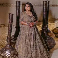 A stunning portrait of the bride posing with elegant floor vases. Her regal lehenga and confident pose create a majestic image.