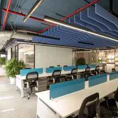 An open-plan office needs to feel both collaborative and organized. For EaseMyTrip, I used a beach-inspired theme with a wave-like acoustic ceiling in a calming blue. This not only manages sound but also visually defines the workspace, while ample greenery and clean desk lines promote productivity and well-being.