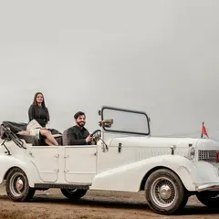 Pre-wedding shoots are all about telling your unique story. For this session, we used a vintage car to create a classic, cinematic feel. This wide shot captures the couple in a stylish pose, suggesting a journey they are beginning together, perfect for a save-the-date or a wedding album intro.
