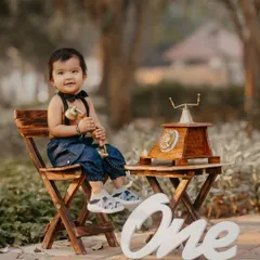 A charming and creative first birthday shoot. The vintage telephone prop and classic outfit give this portrait a unique, nostalgic feel.