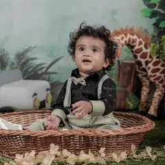 A candid shot of a baby boy in our 'Wild One' jungle set. The soft, natural lighting and green foliage create a beautiful, adventurous atmosphere.