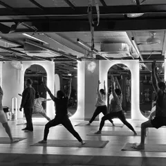 A powerful moment of unity during a group warrior pose. Practicing together amplifies the energy and helps everyone stay motivated and aligned.