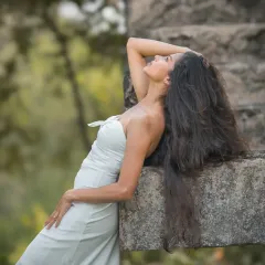 An editorial-style bridal portrait that plays with lines and posture. The stone background and the model's pose create a strong, high-fashion look.