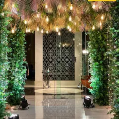 A different angle of the mesmerizing tropical entrance. The reflection on the marble floor and the spotlights enhance the dramatic effect of the green and gold decor.